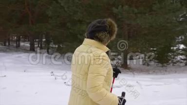 老年妇女在冬林散步。 冬天<strong>北欧漫步</strong>在雪林中